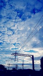 Low angle view of silhouette electricity pylon against sky