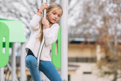 Girl playing on pole in playground