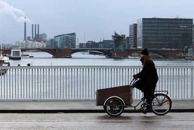 Man riding motorcycle on street against buildings in city