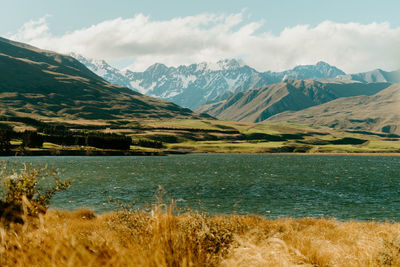 Scenic view of sea and mountains against sky