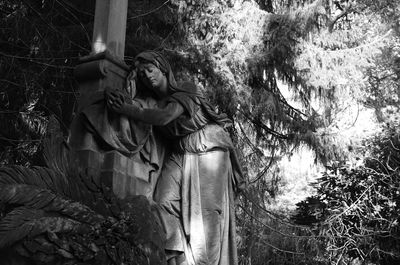 Statue against trees in forest