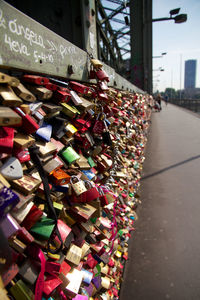 Close-up of padlocks hanging on bridge in city