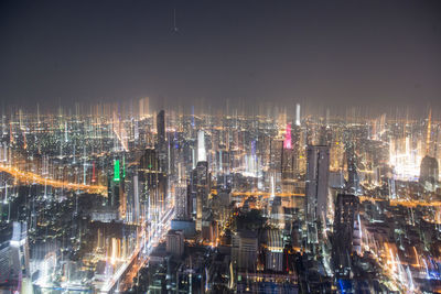 Aerial view of illuminated modern buildings in city at night