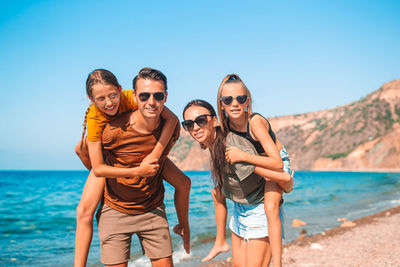 Portrait of friends wearing sunglasses against sky