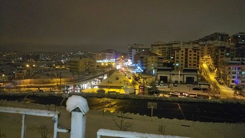 Illuminated cityscape against sky at night