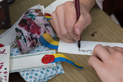 High angle view of girl writing on paper