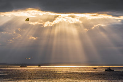 Scenic view of sea against cloudy sky during sunset