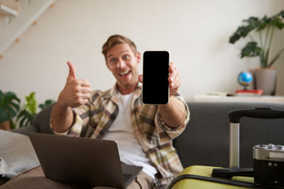 Young woman using mobile phone while sitting on table