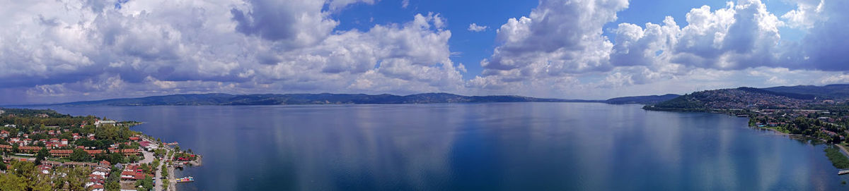 Panoramic view of sea and cityscape against sky