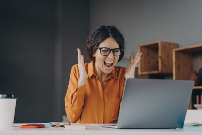 Frustrated woman sitting by laptop at office