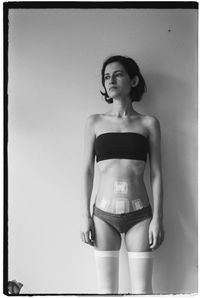 Young woman standing against wall