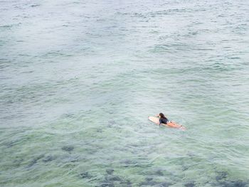 High angle view of woman surfboarding in sea