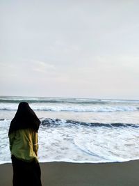 Rear view of man standing on beach