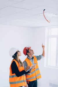 Architect showing ceiling to coworker