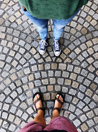 Low section of friends standing on cobblestone street