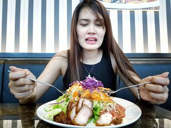 Woman having food while sitting at table