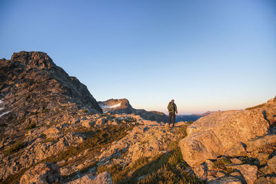 Rear view of backpacker exploring mountain range.