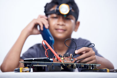 Young schoolboy learning electronic circuit board. detail focus on board component