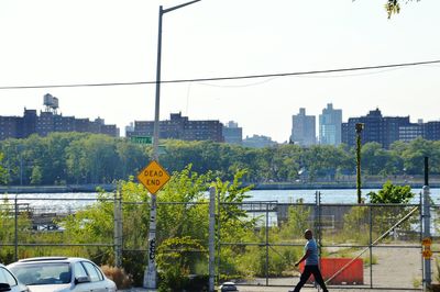 Rear view of people on road in city against clear sky