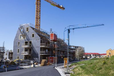 View of construction site with building crane against blue sky