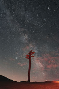 Low angle view of cross against sky at night
