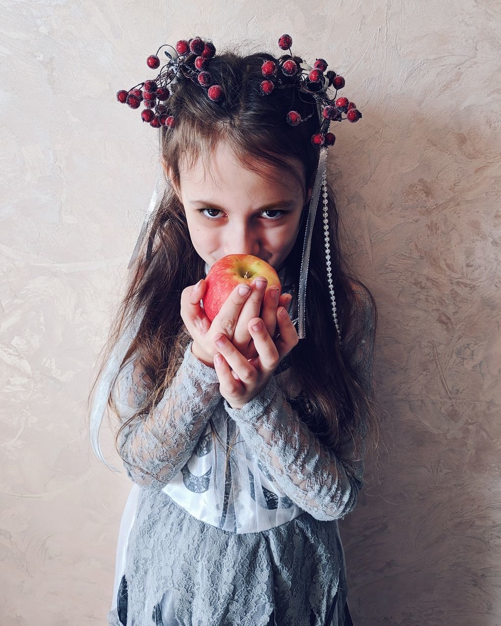 PORTRAIT OF WOMAN HOLDING STRAWBERRY AGAINST WALL