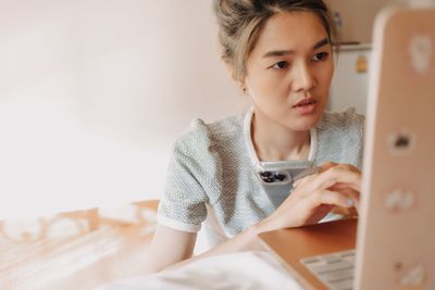 Young woman using laptop at home