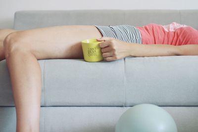 Midsection of woman holding ice cream at home