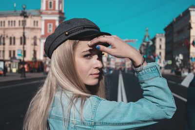 Portrait of woman wearing hat in city