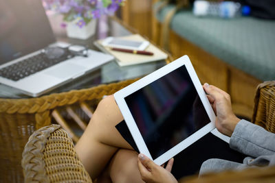 Midsection of man using smart phone on table