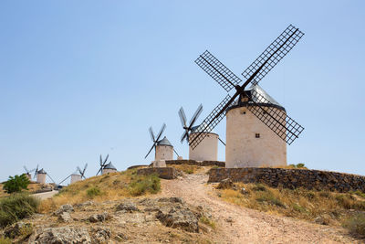 Traditional windmill on land against clear sky