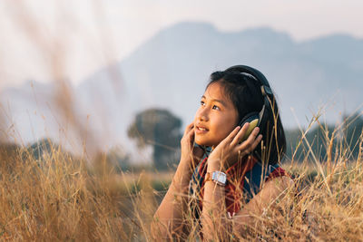 Girl listening to music on field