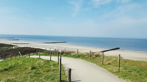 View of calm beach against blue sky