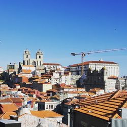 Buildings in city against clear blue sky