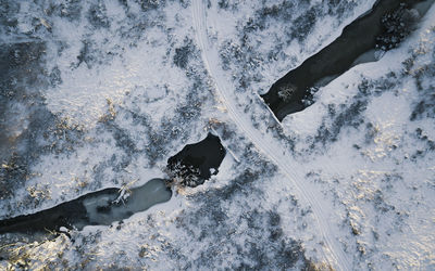 Aerial view of river on snow covered land during winter