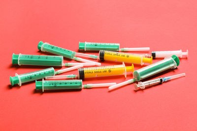 Directly above shot of multi colored clothespins against coral background