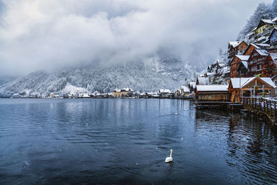 Scenic view of lake by buildings against sky