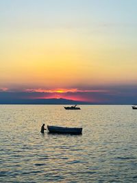 Silhouette boat in sea against sky during sunset