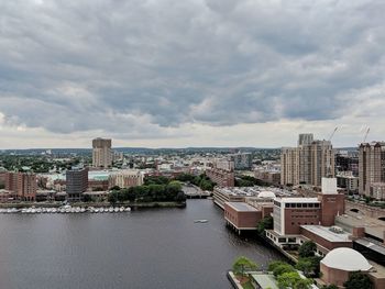 High angle view of buildings by river against sky