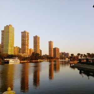 City by river against clear sky