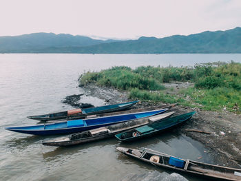 Boats moored in lake against sky