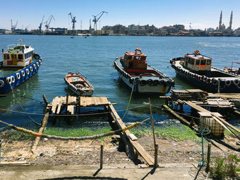 Boats moored at harbor against sky