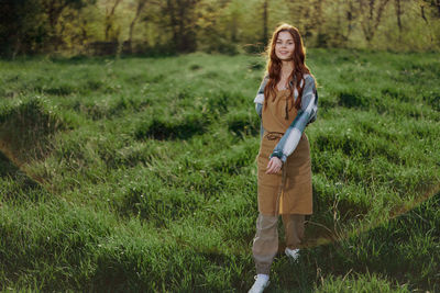 Portrait of young woman standing on field