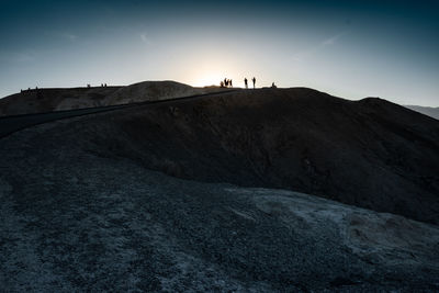 Silhouette people on land against sky