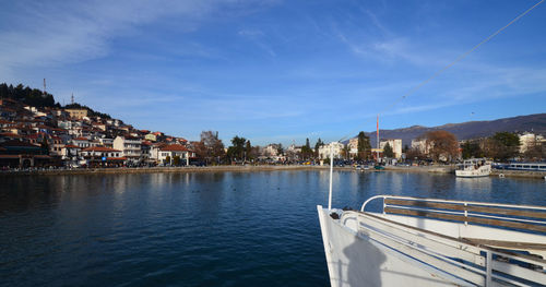 Scenic view of river by city against sky