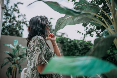 Rear view of woman standing by plants