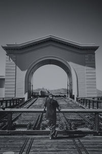 Rear view of man overlooking arched structure