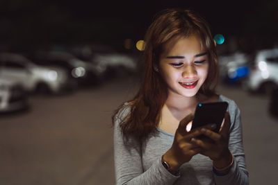 Portrait of smiling woman using mobile phone