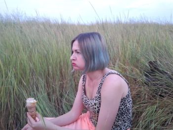 Side view of beautiful woman drinking water on field