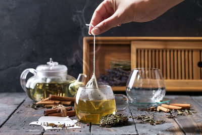 Cropped image of woman preparing herbal tea on table